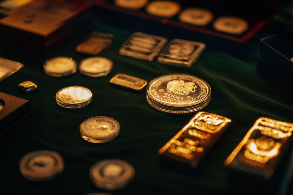 Goldmünzen und Goldbarren auf grünem Tuch, Edelmetalle im Wahre-Werte-Plan
